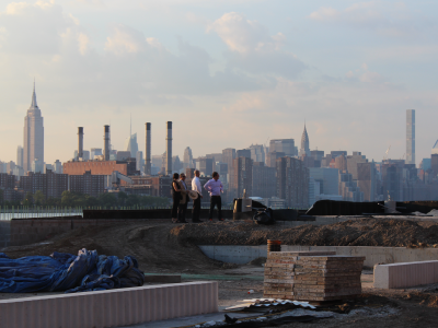 A wide shot of real estate experts evaluating a site, with the skyline in the background